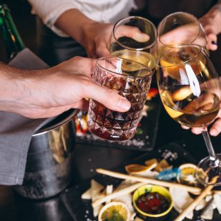 Male and female hands close up with cocktails